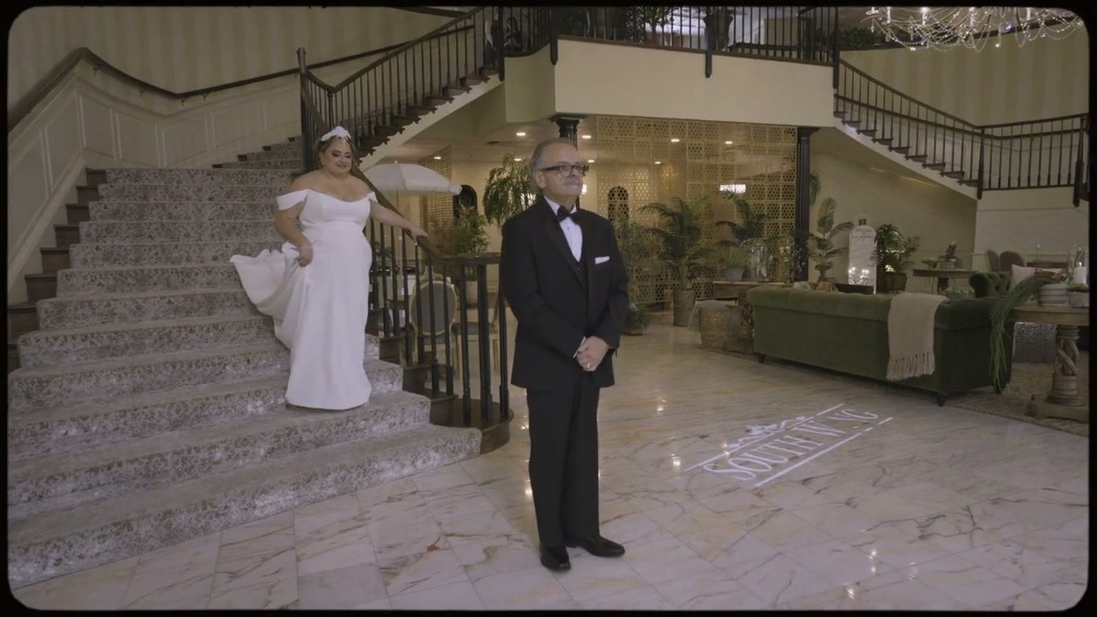 Bride descending the grand foyer staircase at Spring Mill Manor